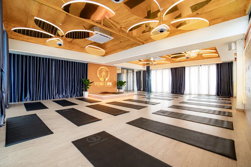 A practice room laid out with mats, facing the Yoga Life feature wall