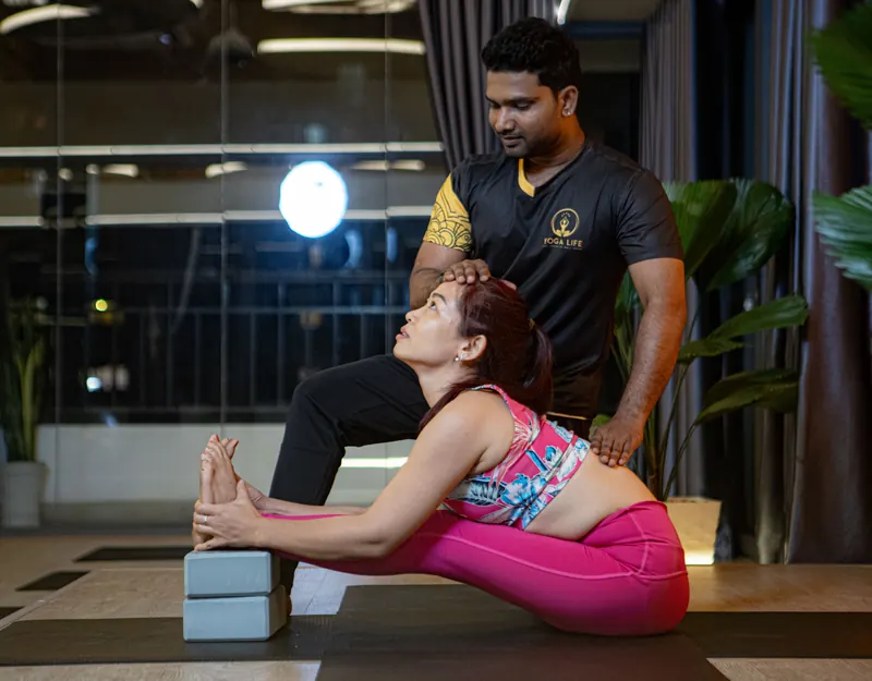 A teacher guiding a student one-to-one in a supported seated posture